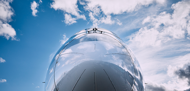 Reflective aerospace vehicle against blue sky, showcasing mission expertise.