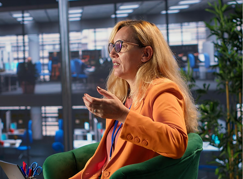 Woman in orange blazer speaking at an event for the IT Leadership Track.