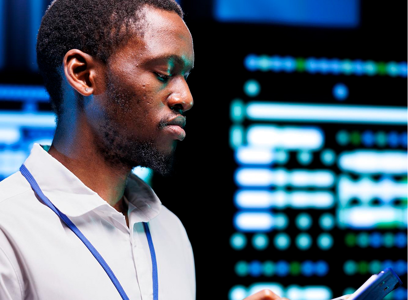 Focused man analyzing glowing data displays, part of the Cyber Security Track.