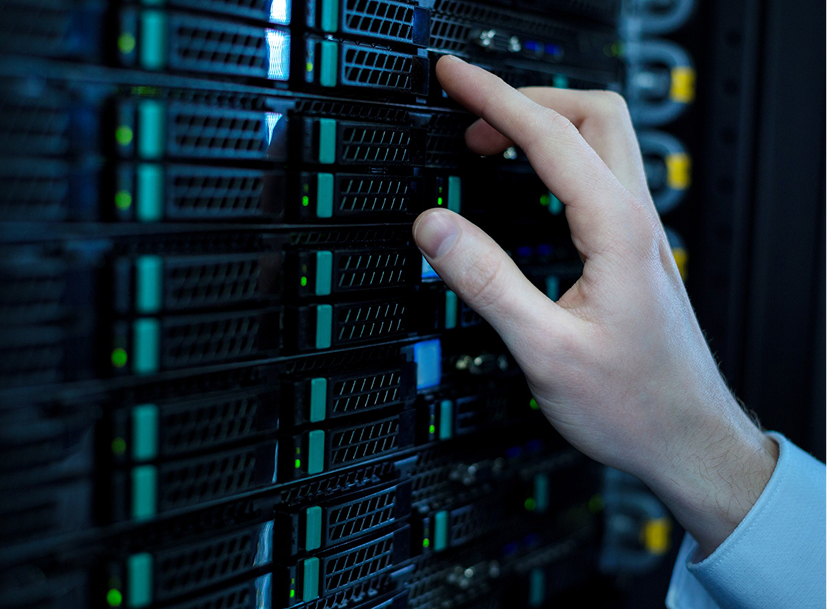 Hand touching a server rack in a data center, representing an IT career track.