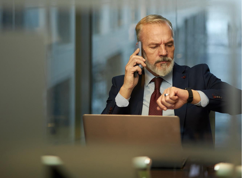 IT leader on phone checking watch, managing time and responsibilities for the IT Leadership Track.